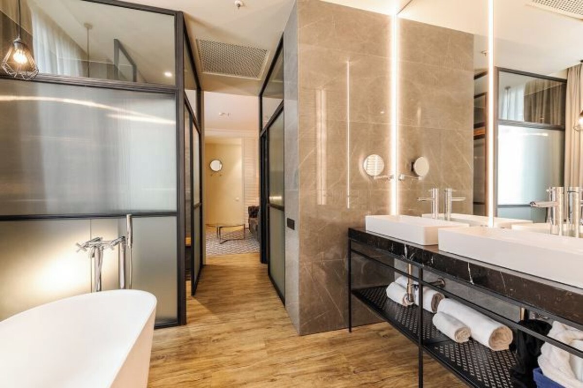 A modern bathroom with a freestanding bathtub, a vanity with dual sinks, and a large mirror.