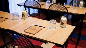Un tavolo da conferenza con quaderni, penne e caraffe d'acqua.