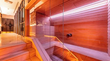 Un interno moderno con una scala che conduce a un livello inferiore, una parete divisoria in vetro e un muro di legno con linee orizzontali.