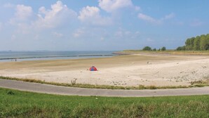 Une plage avec une tente, une route et une zone herbeuse.