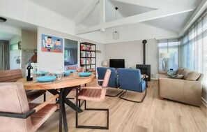 Cozy living space with a round dining table, bookshelf, and comfortable seating area.