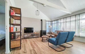 Cozy living space with a fireplace, flat-screen TV, and bookshelf.