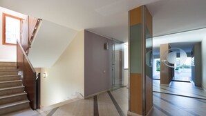 A modern interior with a staircase, a glass door, and a tiled floor. - Appartamento 5th Floor (Cagliari)