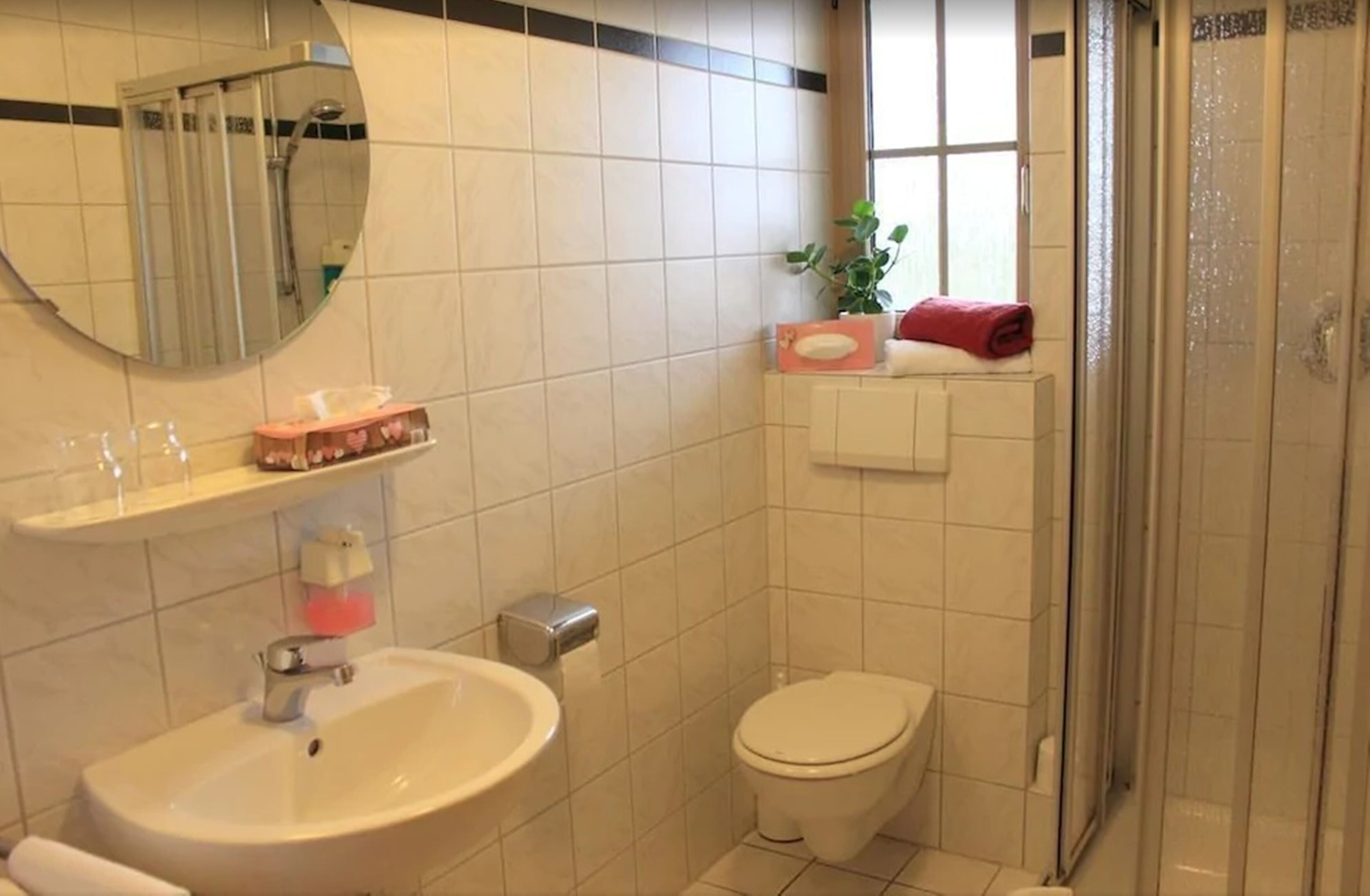 Un baño con lavamanos, inodoro y ducha.