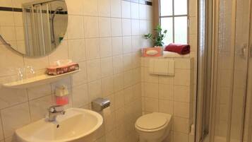 Un baño con lavamanos, inodoro y ducha.