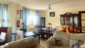 A living room with a dining area, a chandelier, a fire extinguisher, and a cabinet with glass doors. - Casa flamenca en El Ventorrillo (Cullar Vega)