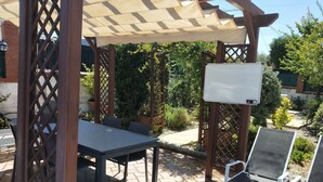 An outdoor patio with a table and chairs, a pergola, and a whiteboard. - Casa flamenca en El Ventorrillo (Cullar Vega)