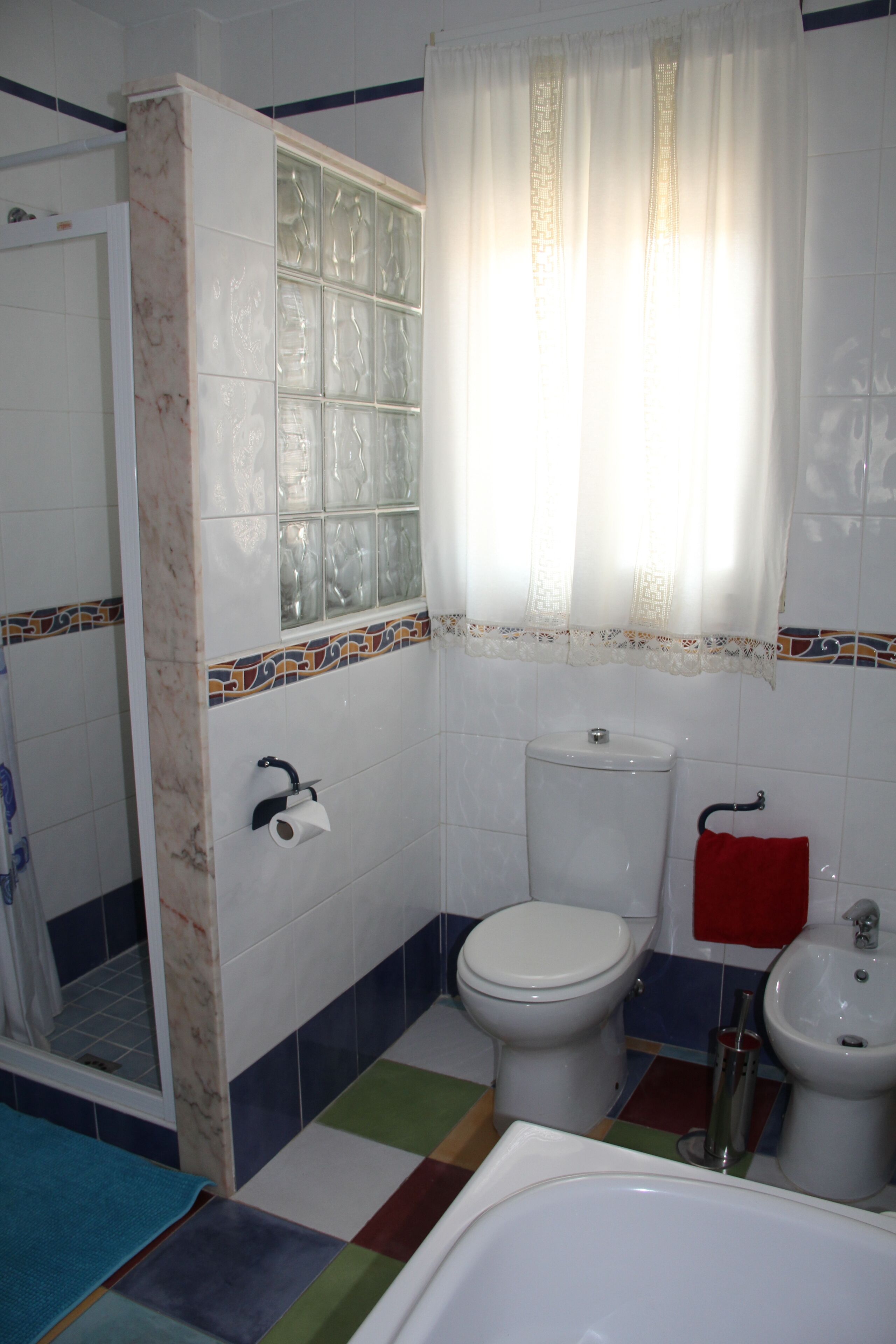 A bathroom with a toilet, bidet, and bathtub.