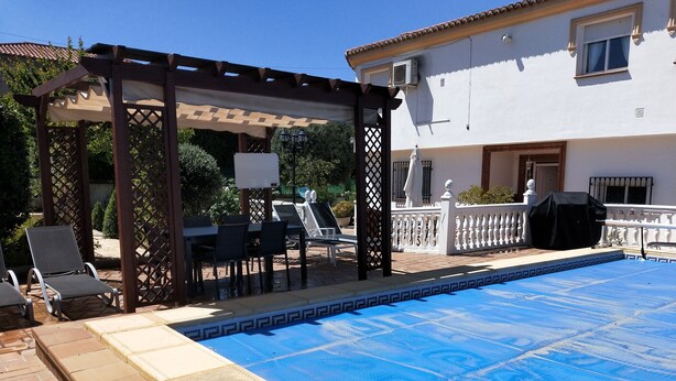 A swimming pool with a pergola and lounge chairs. - Casa flamenca en El Ventorrillo (Cullar Vega)