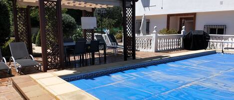 Una piscina al aire libre, sillones reclinables de piscina