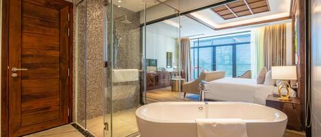 Een moderne badkamer met een vrijstaand bad, een douche met glazen wanden en een houten deur.