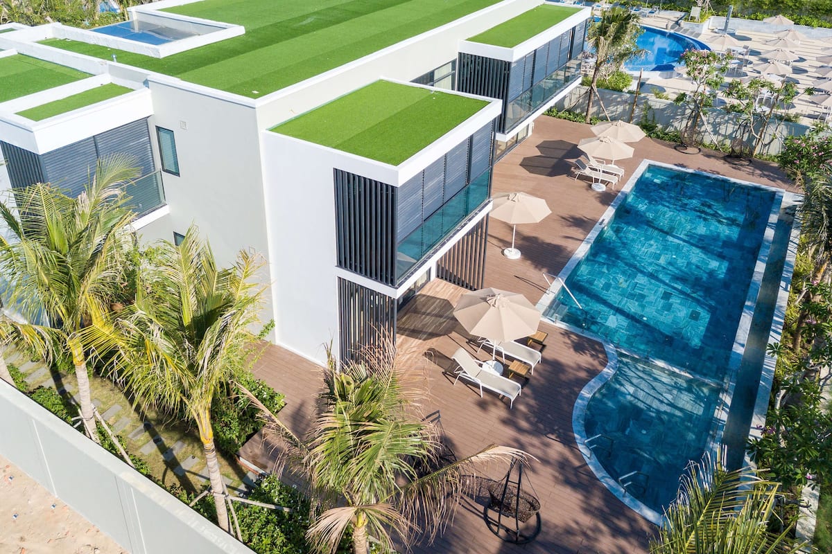 Ein modernes Gebäude mit Dachgarten, Swimmingpool und Außenbereich mit Sitzgelegenheiten.
