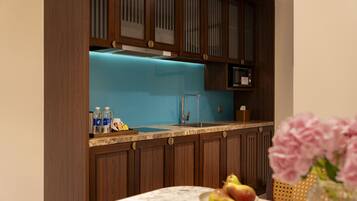 A kitchen with wooden cabinets, a blue backsplash, and a marble countertop.