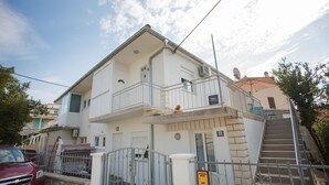 A two-story building with a balcony, a staircase, and a gate. - Apartments Ana (Vodice)