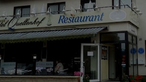 A Café Hotel Quellenhof Restaurant with a visible entrance and a signboard. - Hotel Quellenhof (Bad Breisig)
