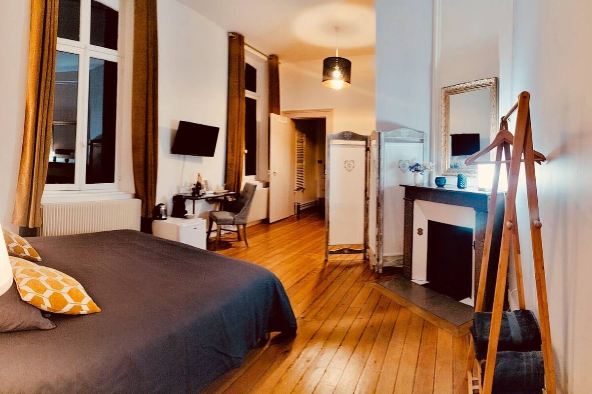 Una camera d'albergo con un letto, una scrivania, una sedia e uno specchio.