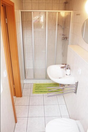 A bathroom with a shower enclosure, a sink, and a toilet. - Ferienwohnungen Margaretenhof (Brandenburg an der Havel)