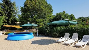 Een buitenzwembad met ligbedden en parasols.