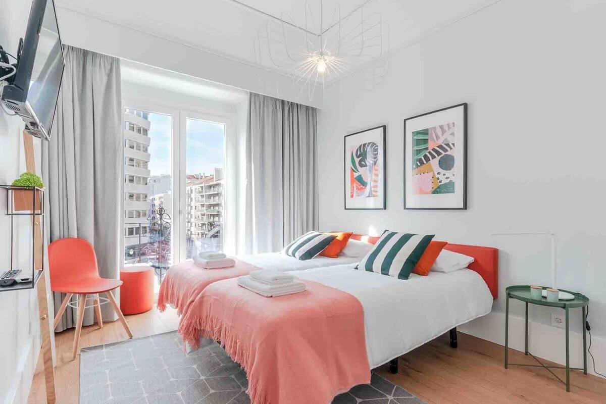 Ein modernes Hotelzimmer mit Bett, Schreibtisch, Stuhl und Blick auf die Stadt.