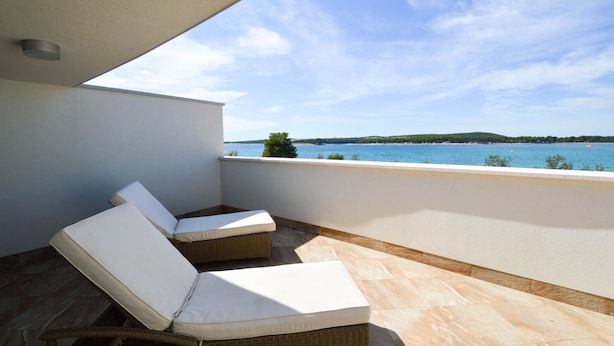 A balcony with two wicker lounge chairs and a view of the sea. - Plavo Nebo Istra Apartments (Medulin)