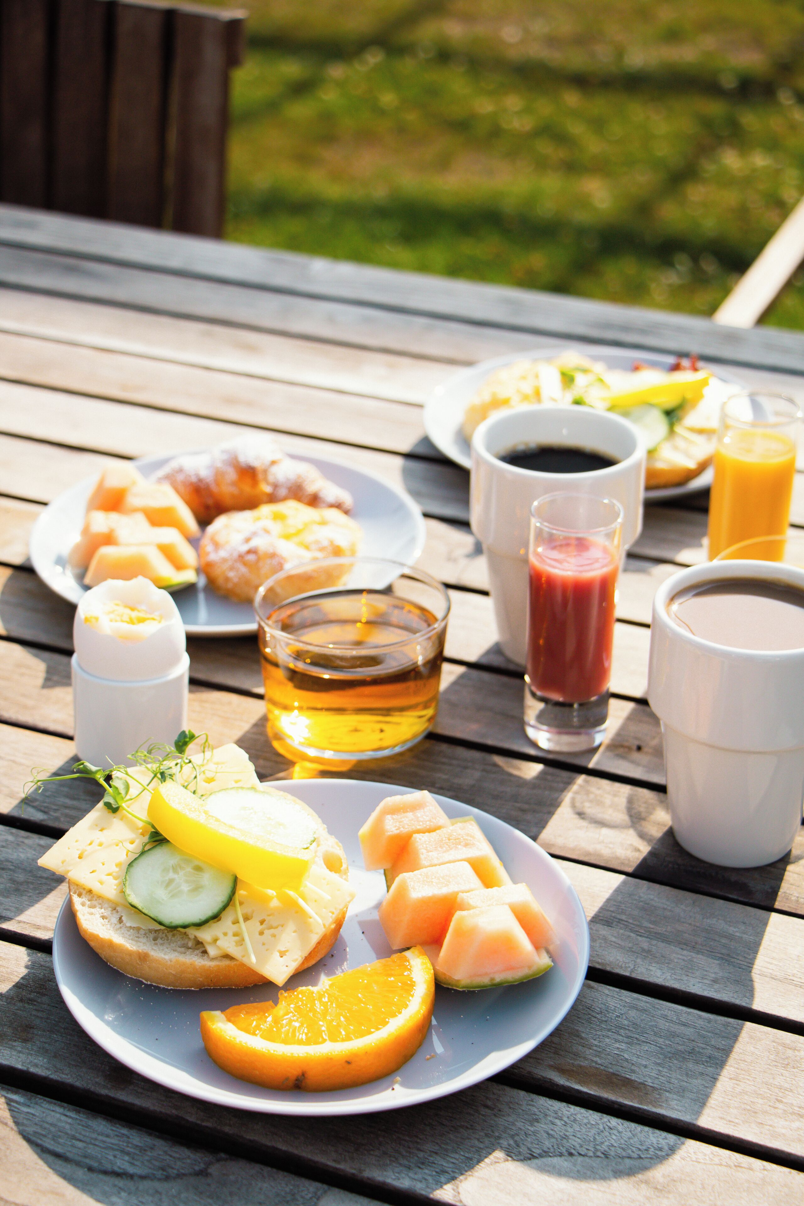 Un montaje para picnic con comida y bebidas sobre una mesa de madera.