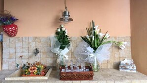 A bathroom with a tiled wall, a hanging light fixture, and a floral arrangement on the counter. - A Pochi Passi dal Mare di Marciana Marina (Marciana Marina)