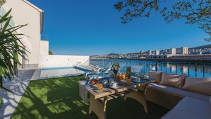 A rooftop pool area with a dining table set for breakfast, overlooking a waterfront cityscape. - Amazing home in Sibenik (Sibenik)