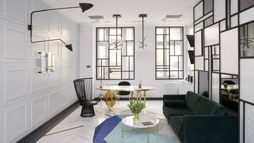 Una sala de estar moderna con un sofá verde, una mesa redonda con un florero, una silla negra y una mesa de comedor con sillas.
