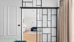A room with a sliding shoji screen, a teal sofa, and a blue chair. - No.4 Residence (Warsaw)