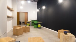 A modern interior with wooden furniture, green barrels, and a black accent wall. - Hostelleria (Trapani)