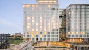 Un hôtel moderne doté d’une façade en verre, de plusieurs étages et d’un atrium central.