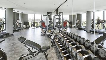 A modern gym with treadmills, weight machines, and dumbbells.