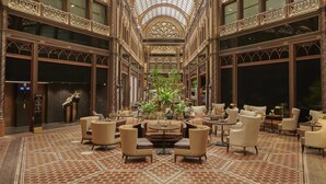 A grand lobby with ornate architecture, a central seating area, and a glass ceiling. - Párisi Udvar Hotel Budapest, part of Hyatt (Budapest)