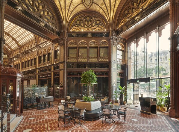 Un interior ornamentado con una zona de estar central, ventanas amplias y un techo alto con diseños intrincados.