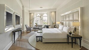 A hotel room with a large bed, a desk, a chair, a TV, and a window with curtains. - Párisi Udvar Hotel Budapest, part of Hyatt (Budapest)