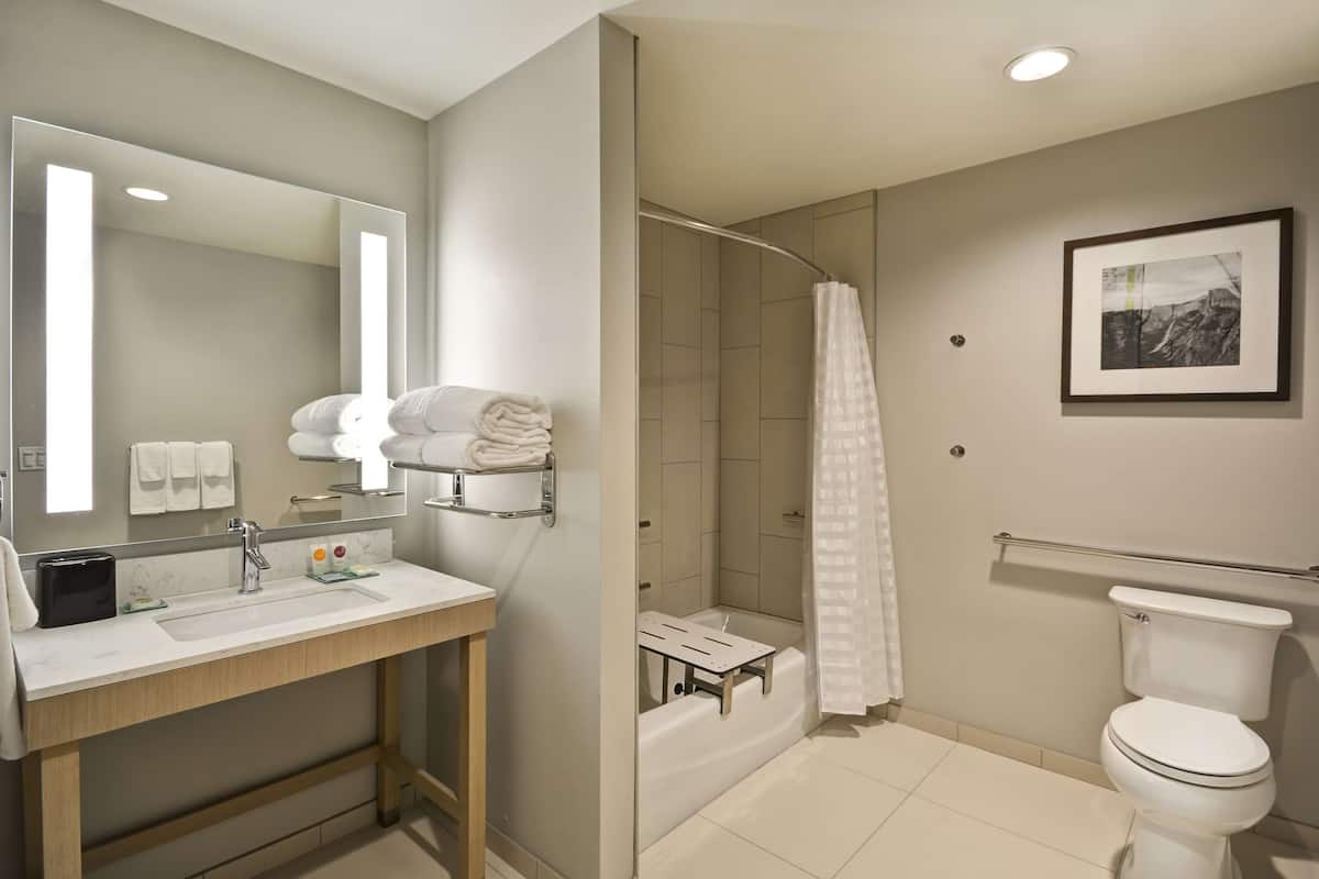 Ein modernes Badezimmer mit Waschbecken, Spiegel, Toilette und Dusche.