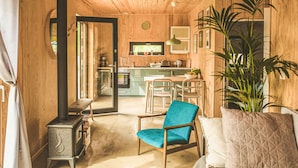 A cozy, wood-paneled room with a dining area, a kitchen, and a large plant. - Beautiful home in Nowe Warpno with WiFi (Nowe Warpno)