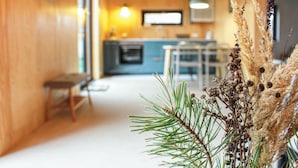 A cozy interior with a wooden wall, a dining area, and a kitchen in the background. - Beautiful home in Nowe Warpno with WiFi (Nowe Warpno)