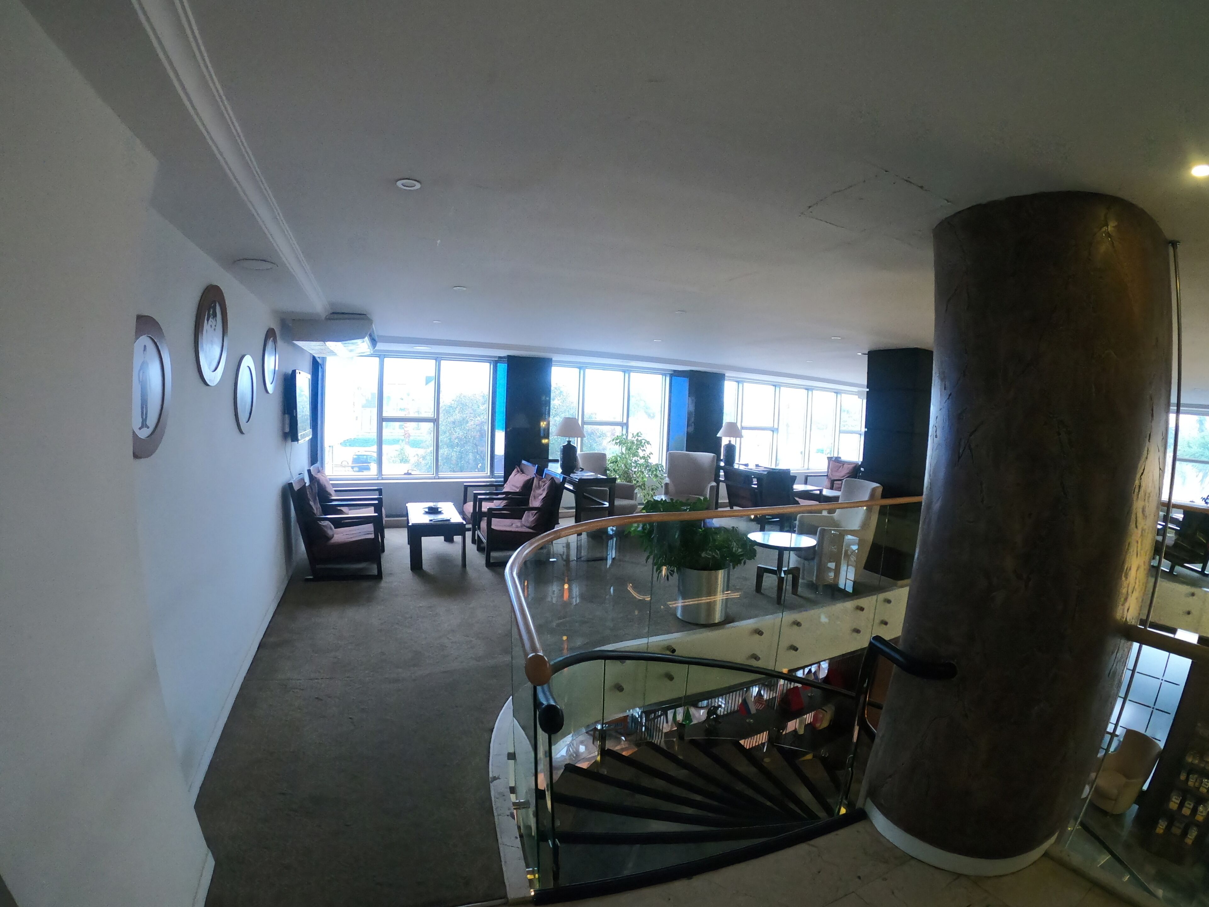 Eine geräumige Lobby mit Treppe, Sitzgelegenheiten und großen Fenstern.