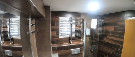 Un baño moderno con ducha, inodoro y tocador.