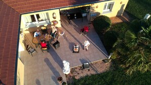 An aerial view of a house with a patio area, outdoor seating, and a covered garage. - Alaguyauder La Chambre (Chatillon-sur-Broue)