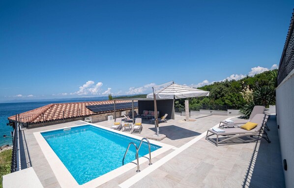 A rooftop pool with a clear view of the sea, a covered seating area, and a poolside lounge. - Stunning home in Loviste (Loviste)