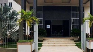 A modern building with a symmetrical facade, large windows, and a central entrance with steps leading up to it. - France Hotel (Guarabira)