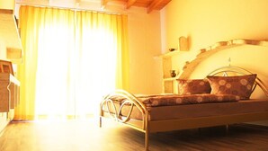 A room with a bed, wooden ceiling, and a window with curtains. - Haus EMG Hockenheim (Hockenheim)