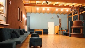 A spacious room with a wooden floor, a sofa set, a bench, and a fireplace. - Haus EMG Hockenheim (Hockenheim)