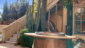A courtyard with a wooden barrel, cacti, and a staircase leading to a balcony. - Villa Limonade (Olonzac)