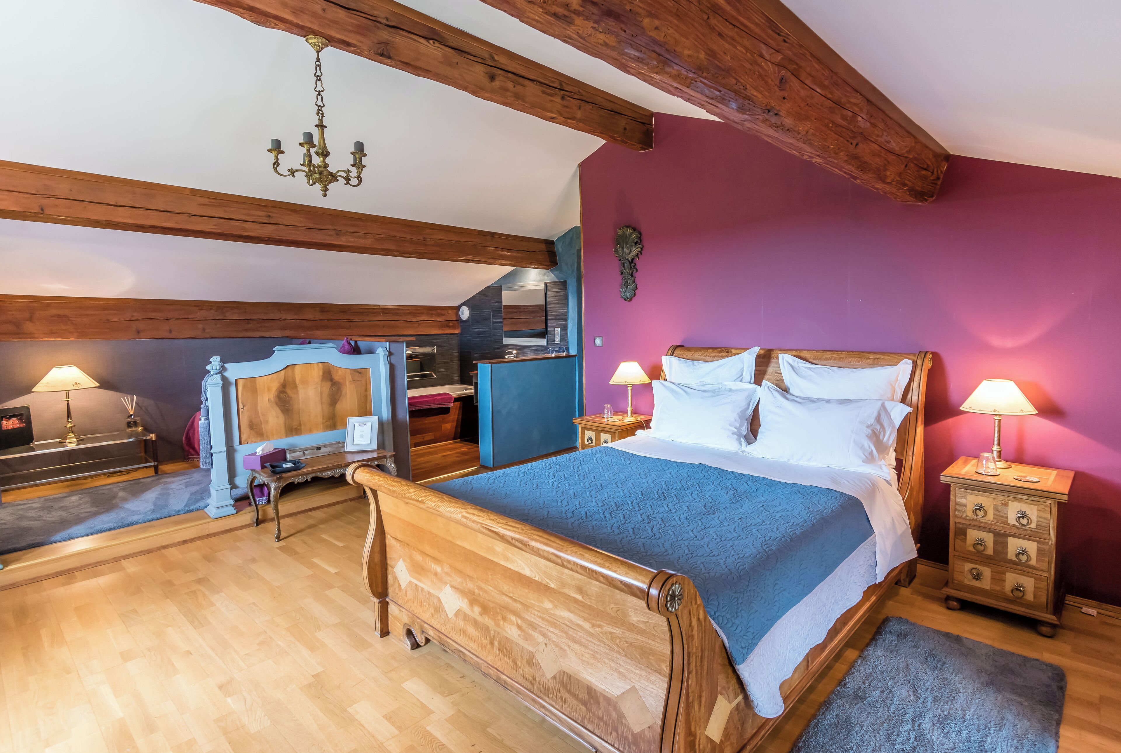 Un dormitorio con cama de madera, una mesita de noche, un aparador, un escritorio y una silla.