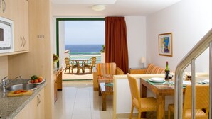 A compact kitchen with a dining area and a view of the ocean. - Aparthotel Esquinzo Y Monte Del Mar (Pajara)