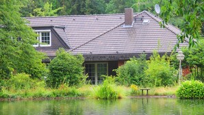 Een huis met een schuin dak, een schoorsteen en een raam.