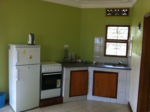 Fridge, microwave, stovetop, cookware/dishes/utensils - Prestige Resort Cottages (Entebbe)